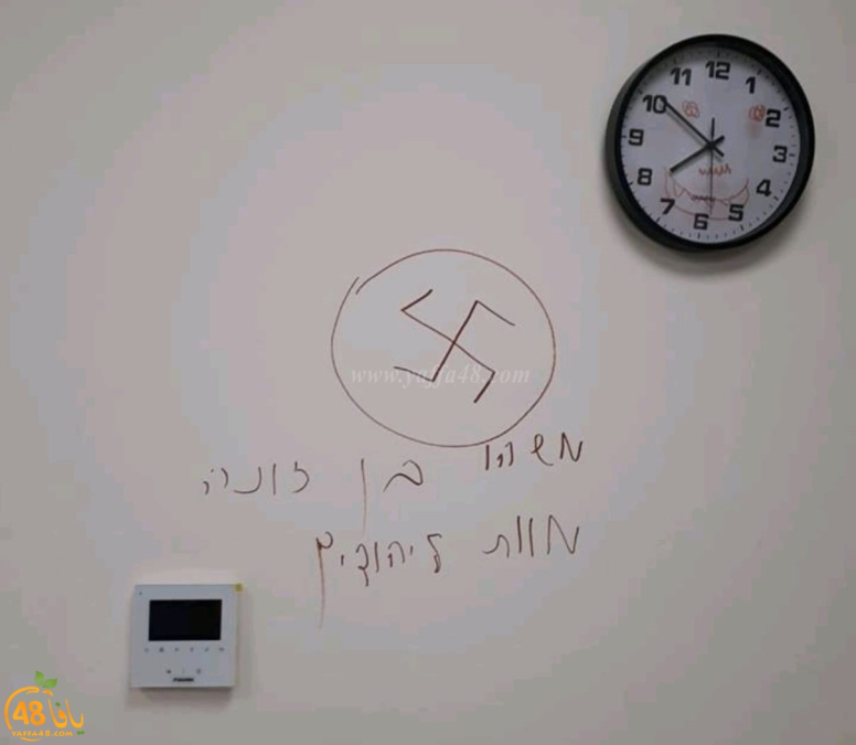  رسم شعارات الصليب المعكوف على جدار احدى الروضات بيافا